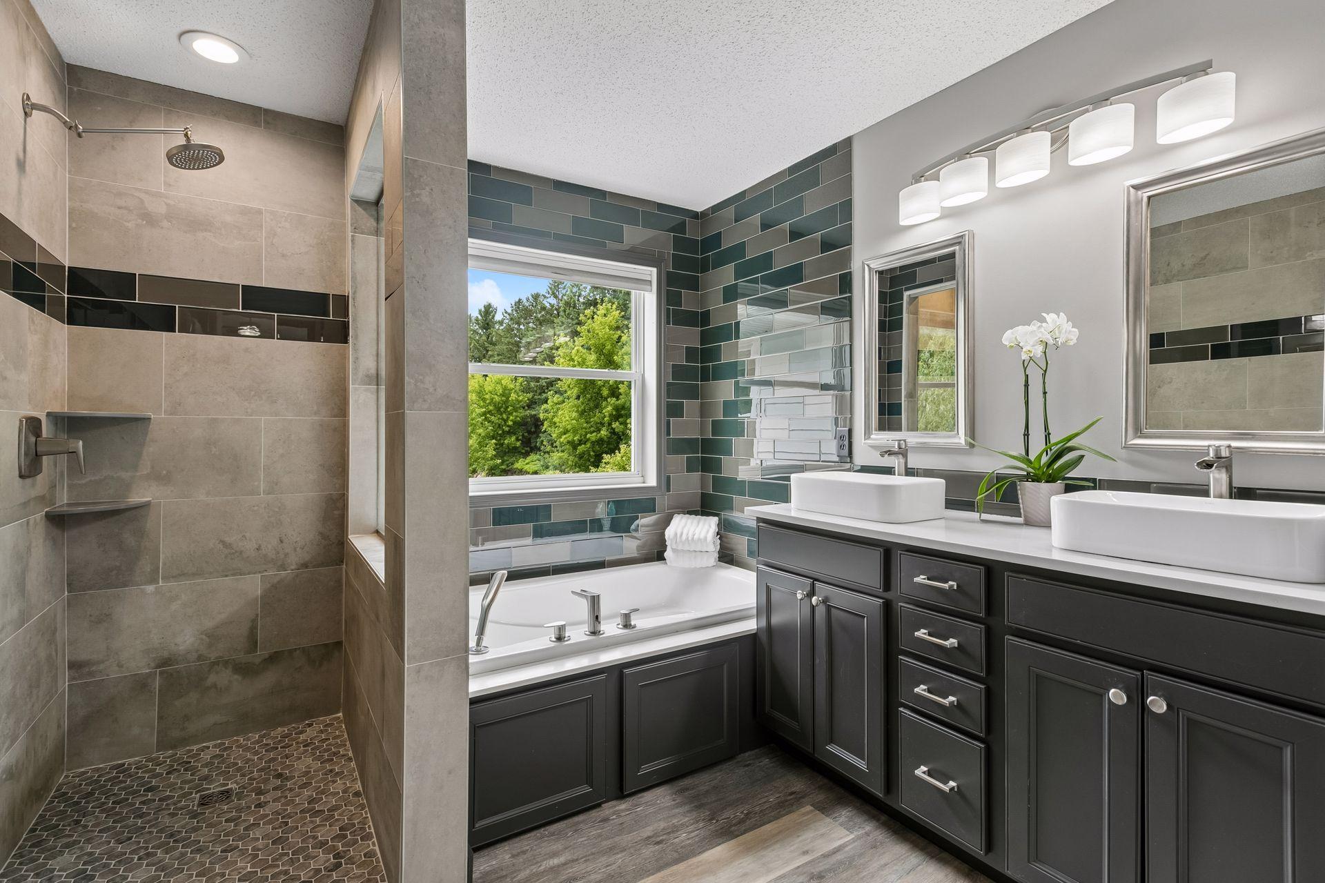 Primary bathroom with step-in tiled shower, separate soaking tub, and double sinks. Beautifully appointed, get away from the hustle and bustle in your own spa-like retreat.