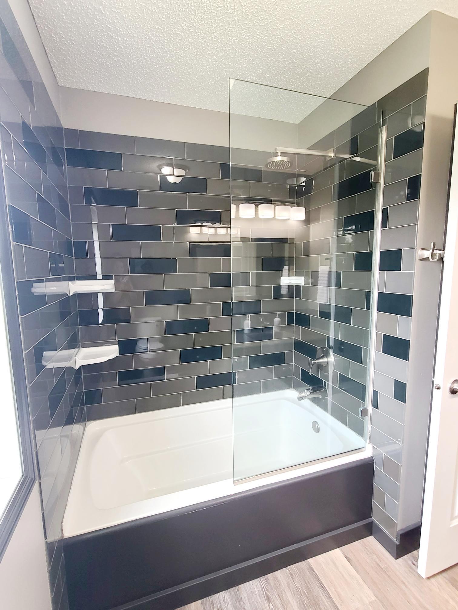 Guest bath tiled tub/shower with glass wall accent