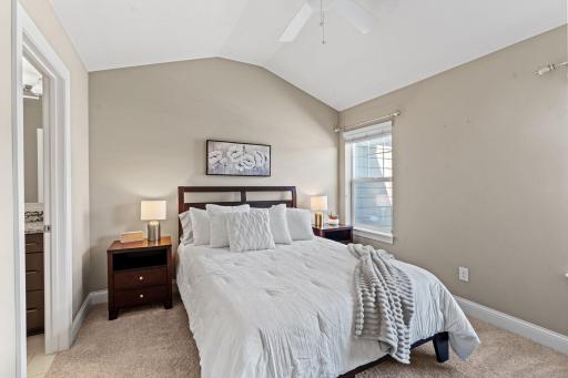 Vaulted Primary Suite w/ ensuite Bath featuring tiled shower, granite counters, 12x24 tile + walk-in closet.