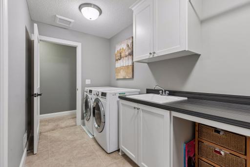 Laundry access from primary suite with sink and folding stations