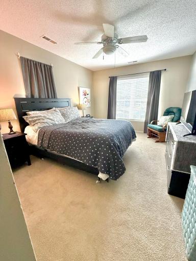 Primary bedroom with two windows; right-side window faces the pond view.