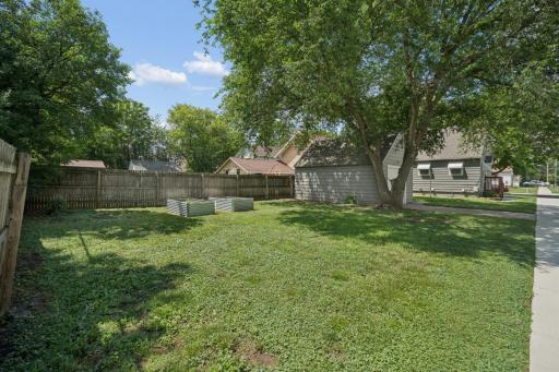Large Partially Fenced Backyard with Two Garden Planters