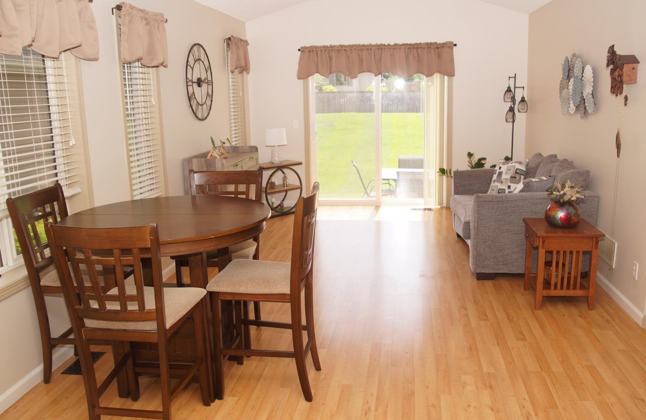 Dining area to living room with newer laminate flooring! Sliding door walks out to concrete patio!