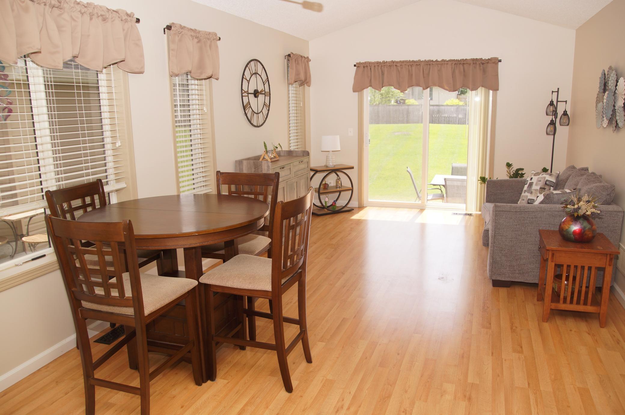 Dining area to living room with newer laminate flooring! Sliding door walks out to concrete patio!