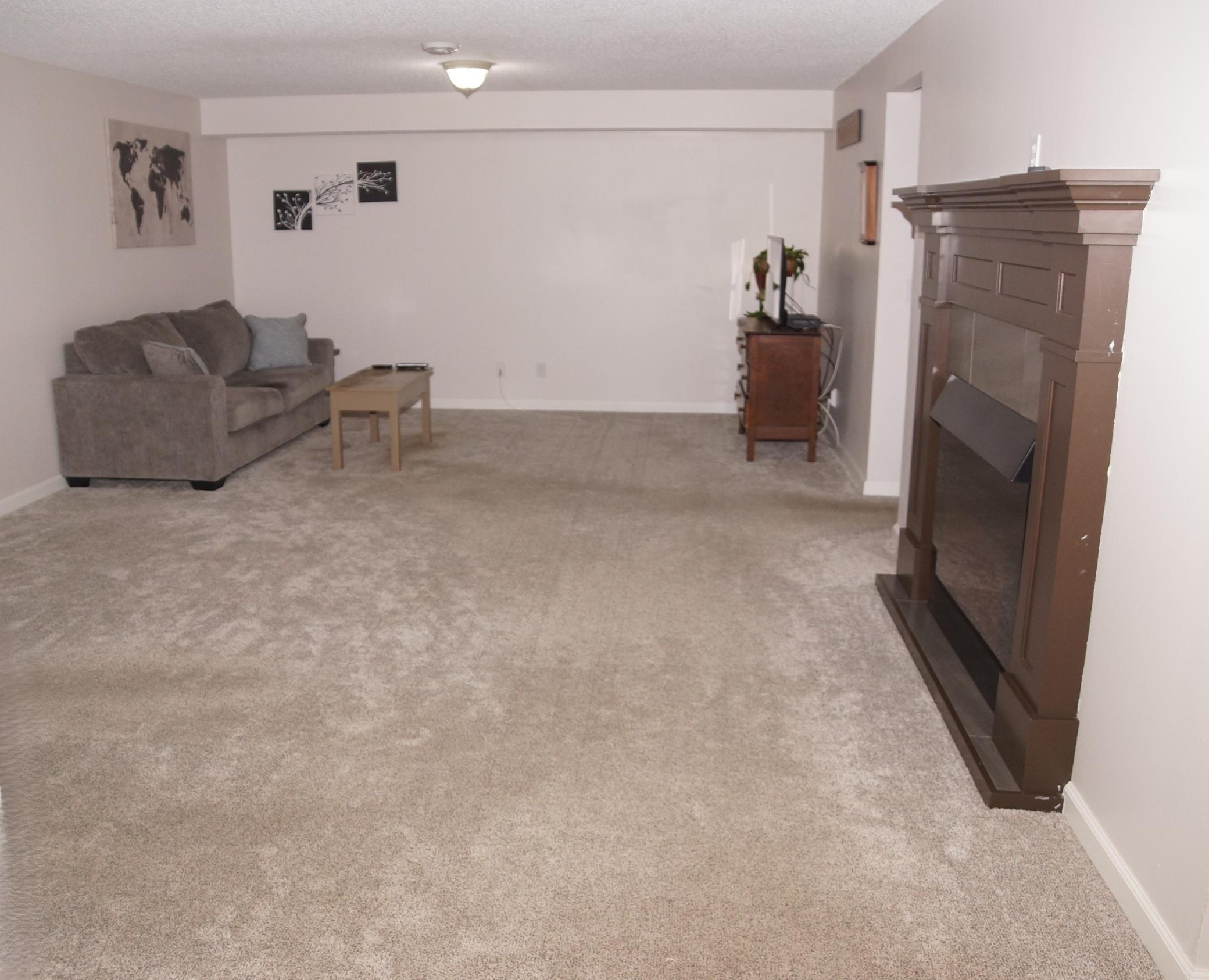 Nice size lower level family room features electric fireplace. Perfect for large sofa and big screen TV!