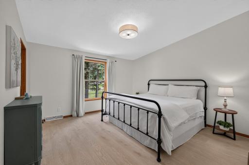 The primary bedroom boasts LVP flooring, abundant natural light, and calming neutral tones.