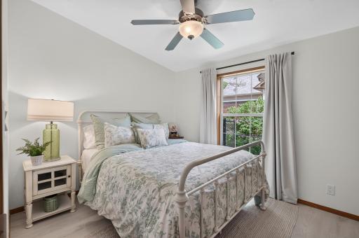 Second bedroom with LVP flooring, natural light, and a ceiling fan for added comfort.