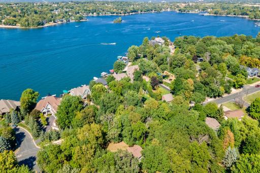Drone view of house in between trees at bottom of picture