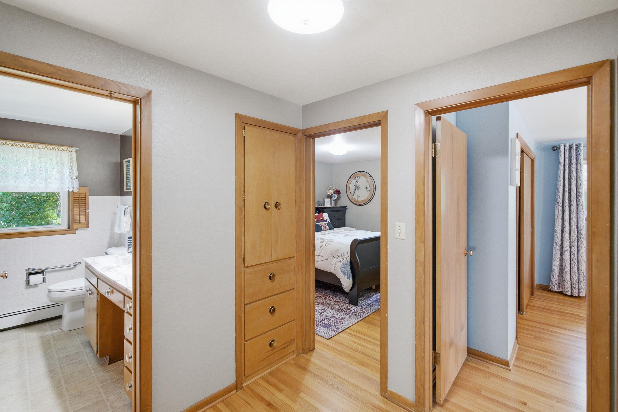 Hallway with hardwood floors and storage.