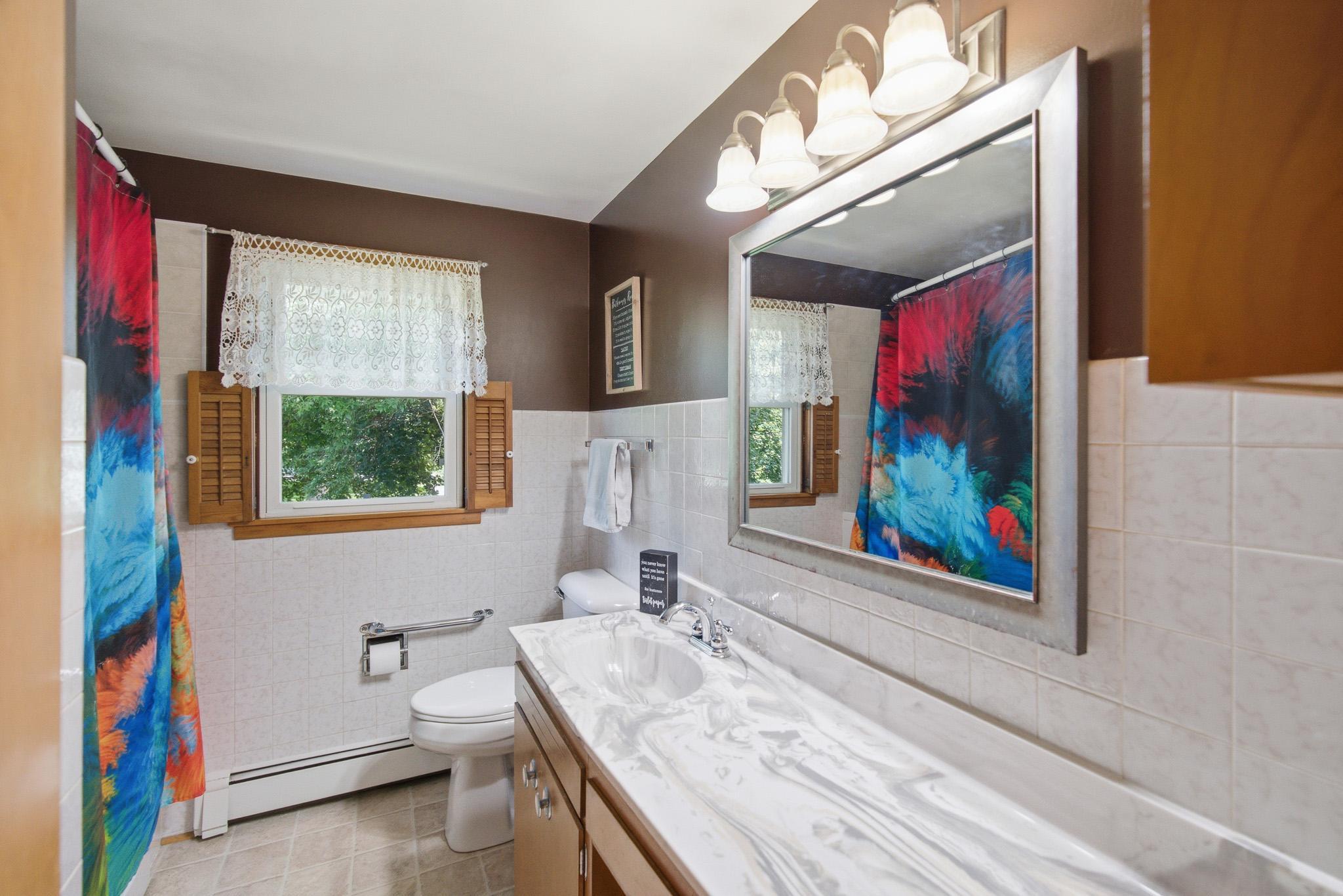 Well maintained full bathroom with an oversized vanity and plenty of storage space.