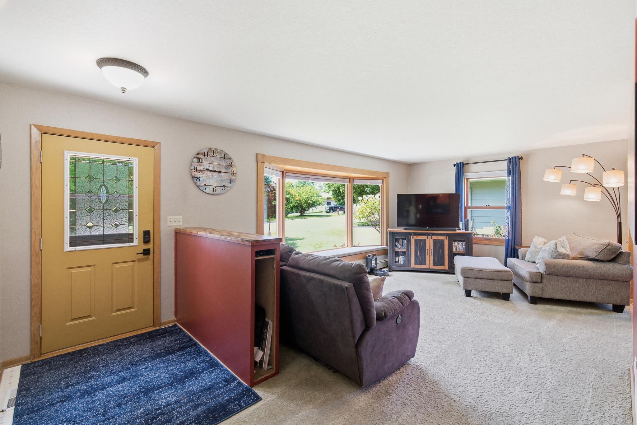 Bright and spacious living room featuring a large picture window that fills the space with natural light.