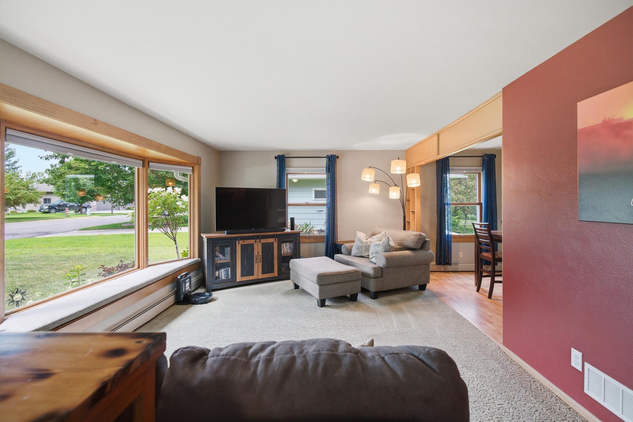 Bright, spacious living room featuring a large picture window that fills the home with natural light and creates a warm, welcoming atmosphere.