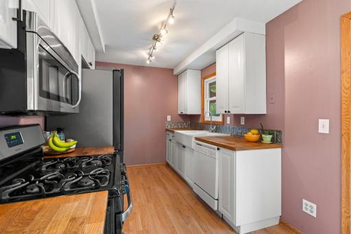 White cabinetry and warm butcher block countertops