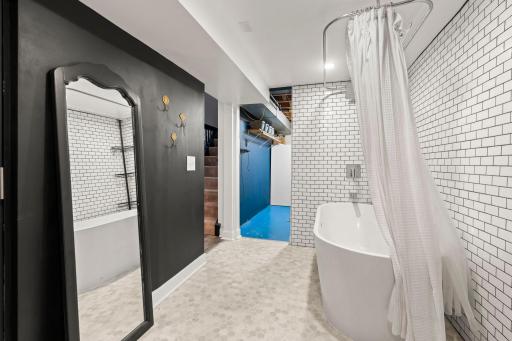 Lower level bathroom with tiled tub and shower surround