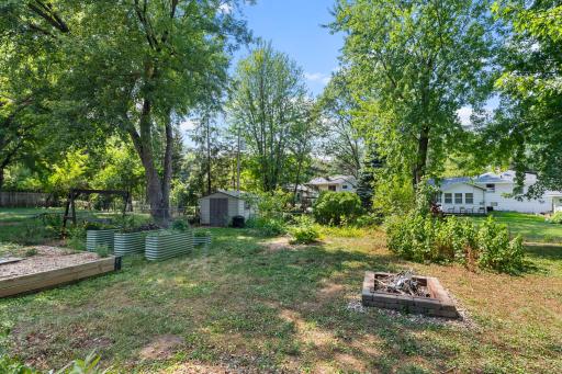 Large backyard with mature trees and garden space