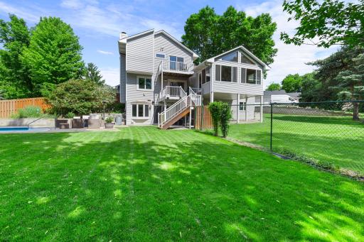 A large yard includes a fenced-in pool area along with additional open space outside the fence, offering plenty of room for outdoor enjoyment