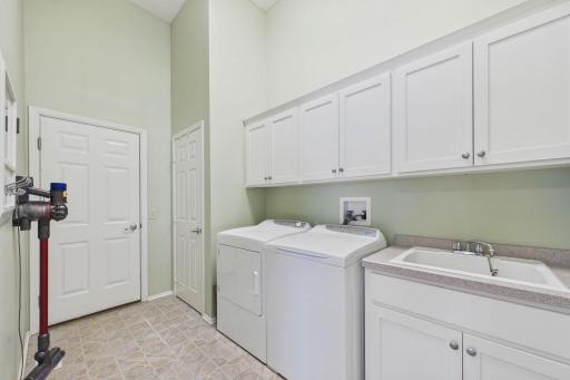 Laundry room with sink and storage. Such a well planned design.