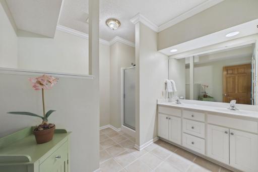 Lower Level ensuite with neutral tile flooring and double vanity.