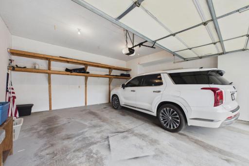 Spacious 2 car garage even has built in shelving for you! Finished walls too.