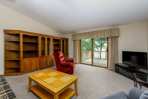 Large living room with lake views and additional patio door to the deck.