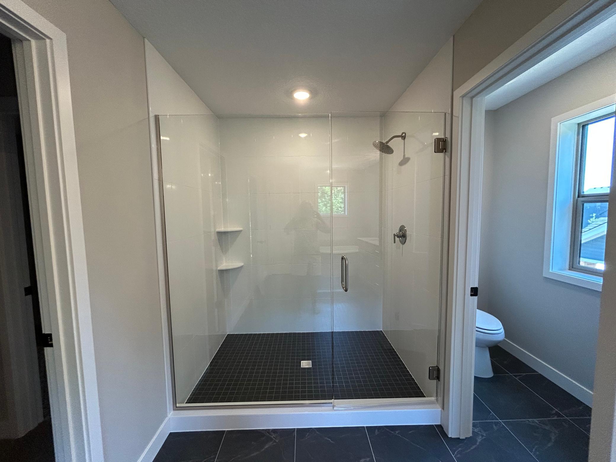 Spacious shower with ceramic tile walls and floor