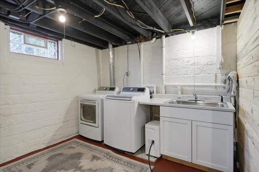 Laundry area with newer machines & large, stainless steel utility sink.