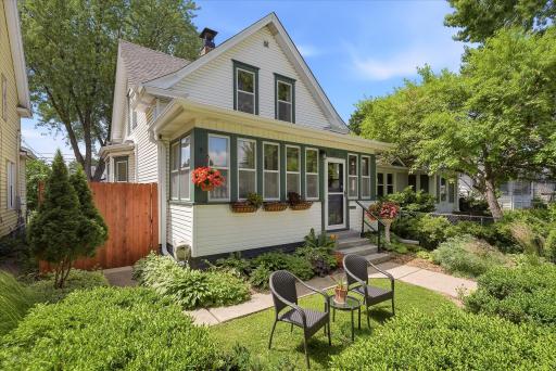 Front yard is surrounded by perennials & greenery, with a nice seating area to enjoy this friendly block.