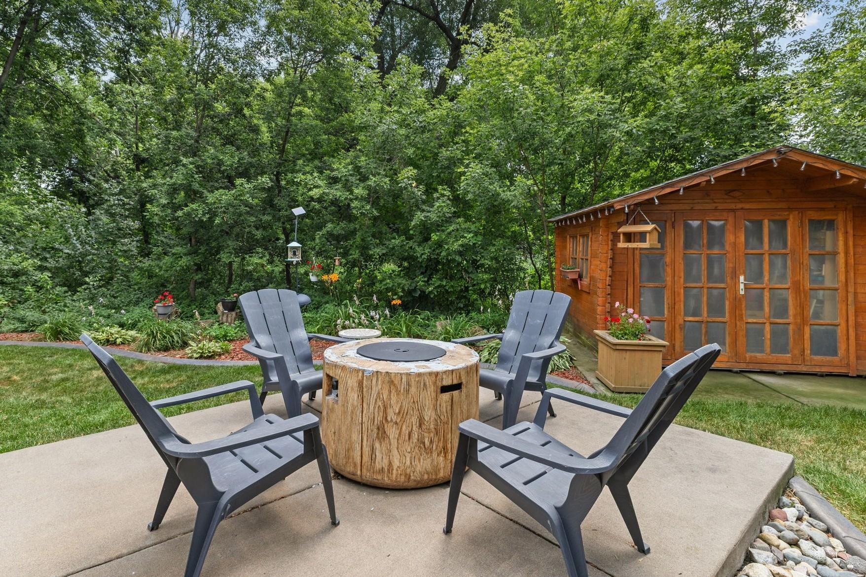 This amazing backyard features multiple living areas including this concrete patio and a low-maintenance composite deck.