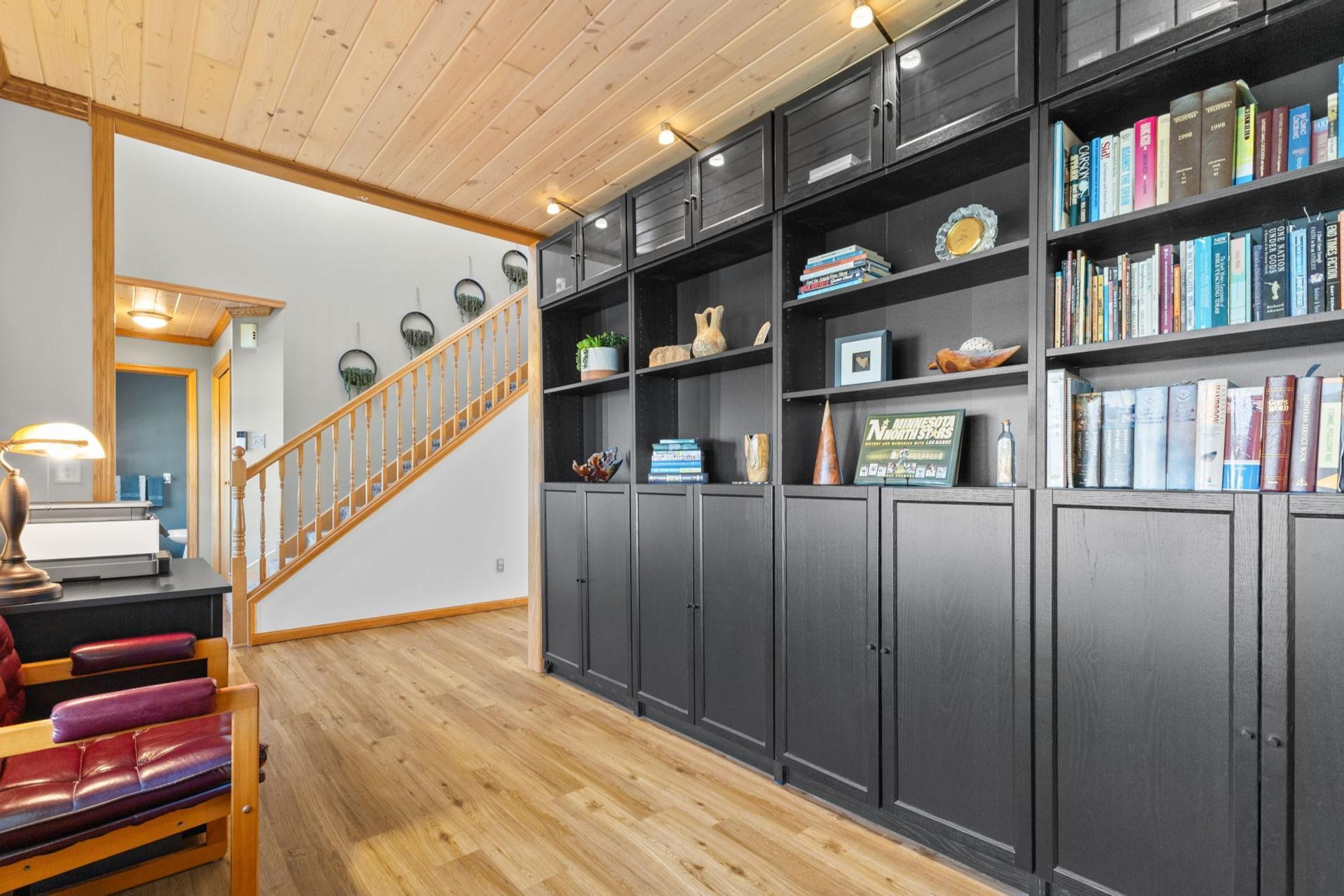 This front room is currently used as an open air office. The featured cabinetry is included in the sale.