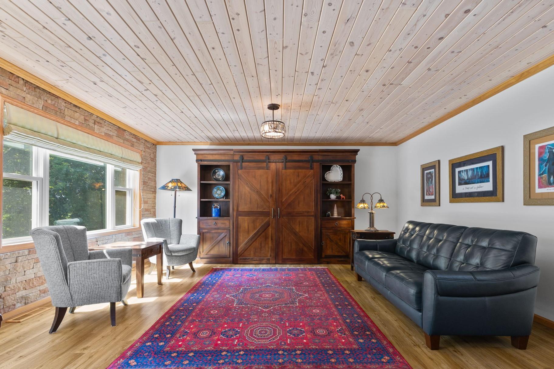 The spacious living room features a unique cedar ceiling, which stretches into the dining and kitchen areas.