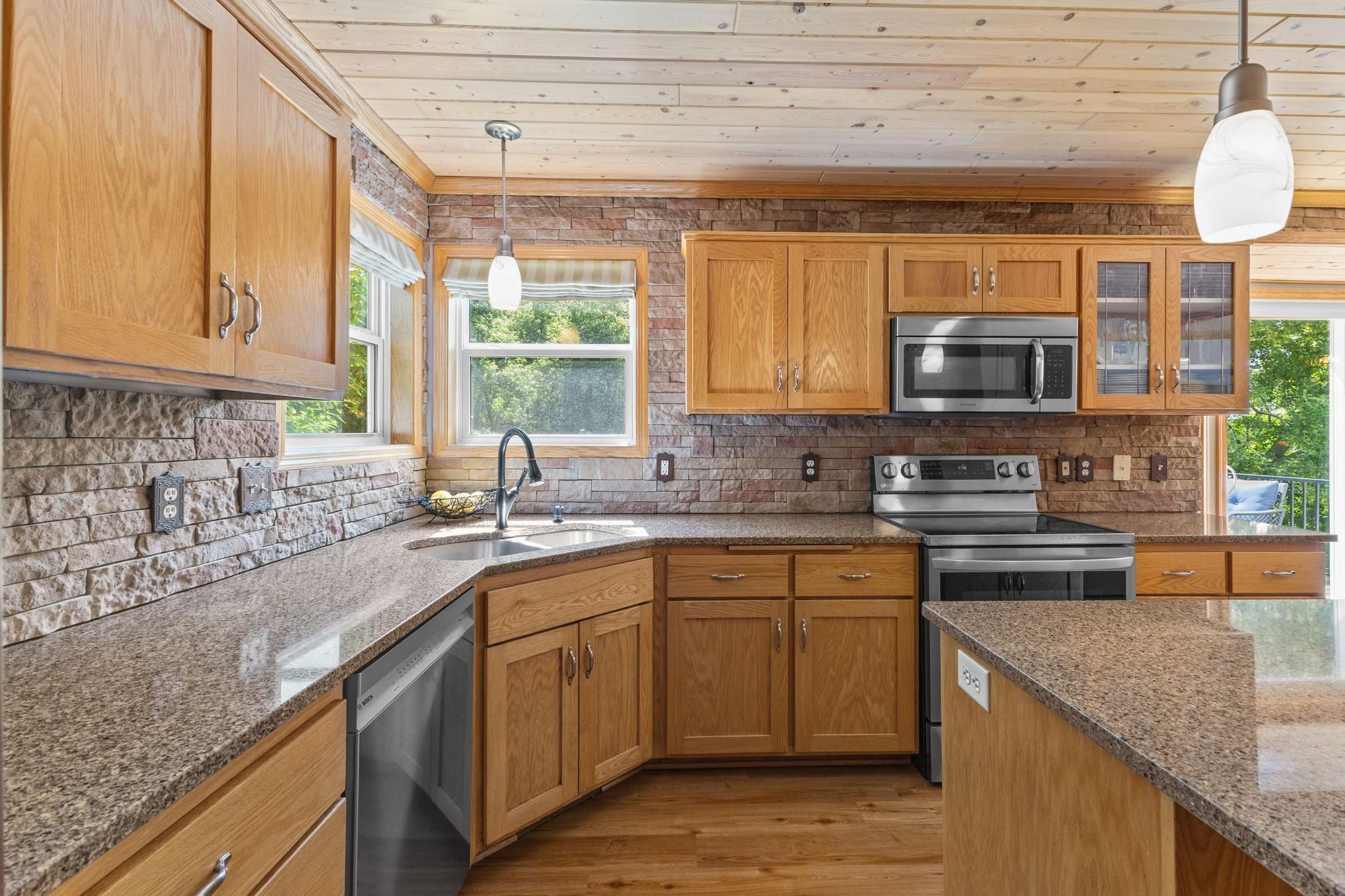 Two walls in the kitchen features a natural stacked stone, creating an upgraded rustic feel.