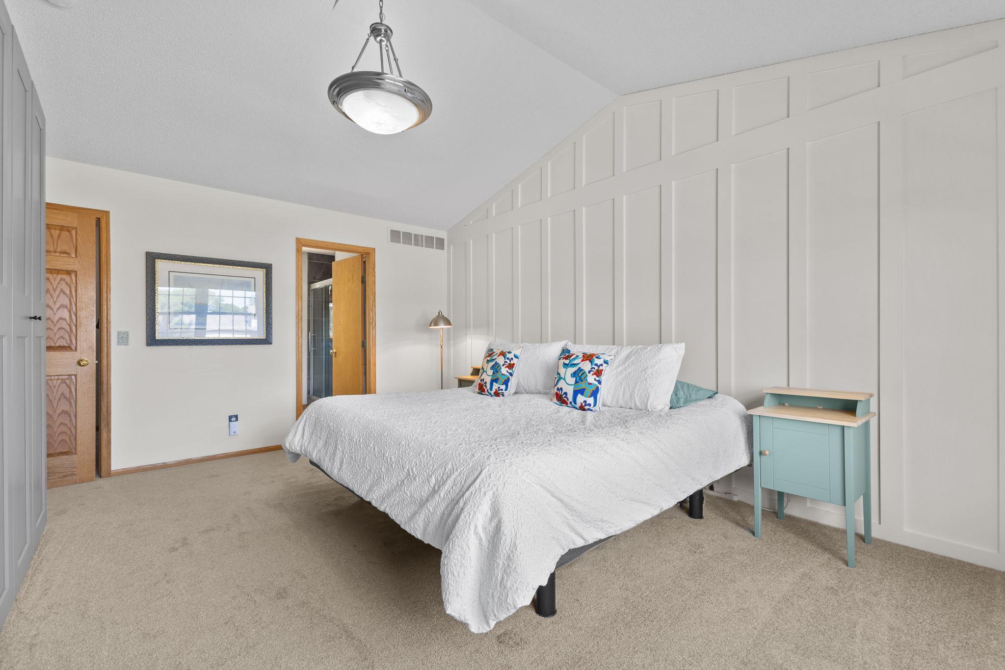 The spacious primary bedroom features a board and batten accent wall, brand new carpet and pad, plus a walk-in closet.