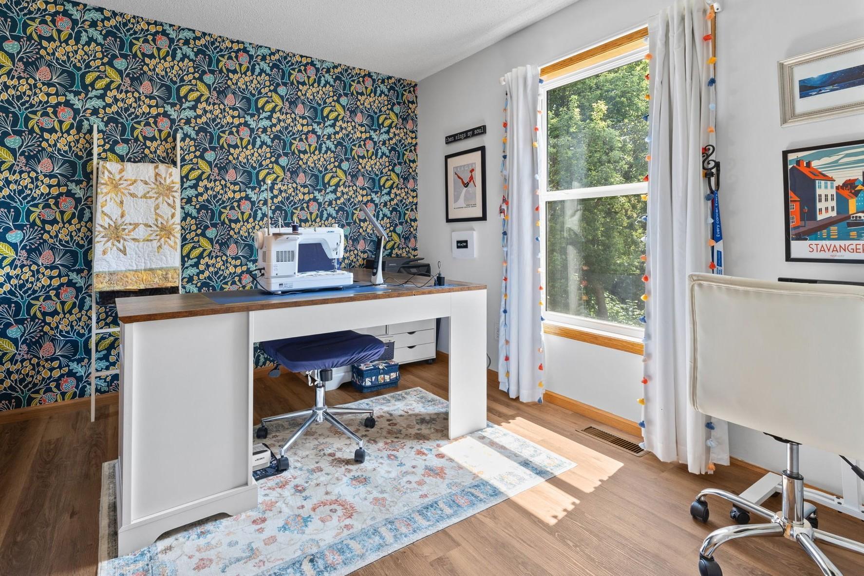 The third upstairs bedroom, currently used as a sewing room, features peel-and-stick wallpaper which can be easily removed if desired.
