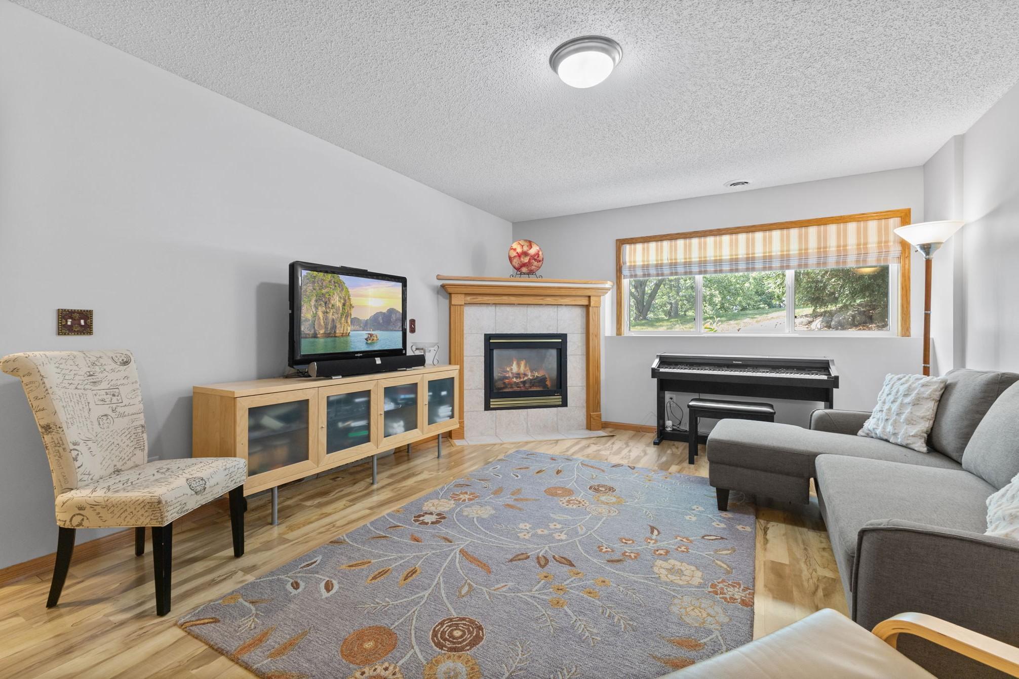 The lower level family room features a gas fireplace and more green views.