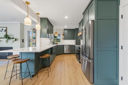 Kitchen offers enameled cabinetry features flat panel doors, roll-out storage, 42” uppers, satin gold hardware, full height pantry, corner sink with large windows and “Eat-In” breakfast counter