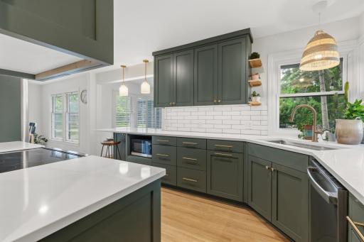 Stainless steel appliances include slide-in range with cabinet paneled hood, french door refrigerator, microwave and dishwasher