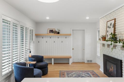 Sitting Room features built-in lockers that features a paneled wall with hooks, solid wood bench and shelf. Custom shutters