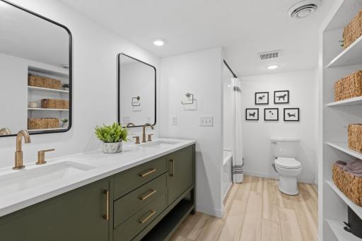 Full Bathroom features a large enameled vanity cabinet with quartz countertop, dual sinks and wide spread faucets. Open storage shelving