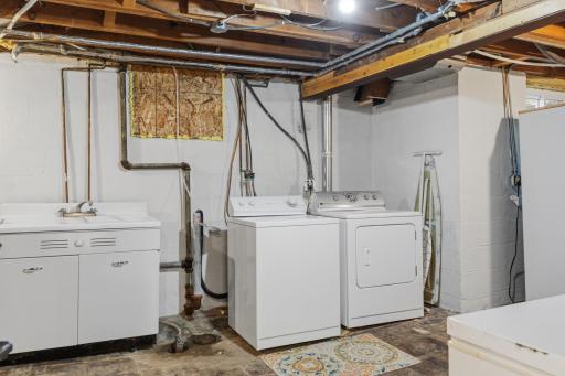 Laundry & Mechanical Room ~ Vintage wall mounted utility sink. Generously sized storage area and built-in storage shelving and workbench