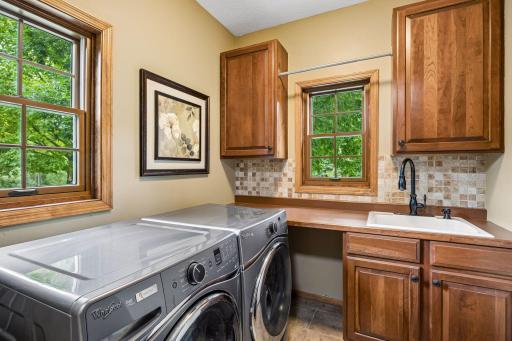 Laundry Room with Ceramic Tile Flooring and Backsplash, Cabinets and Stainless Washer/Dryer