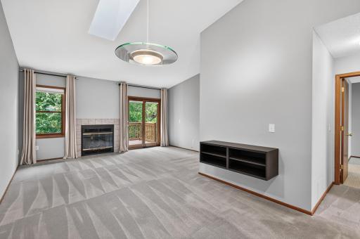 Bright dining area with vaulted ceiling and skylight, open to the living room.