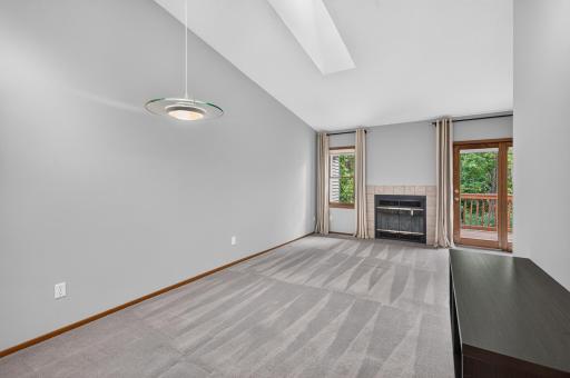 Bright dining area with vaulted ceiling and skylight, open to the living room.