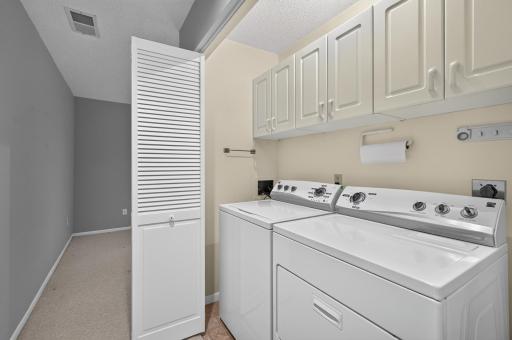 Lower-level laundry closet with convenient built-in cabinetry.