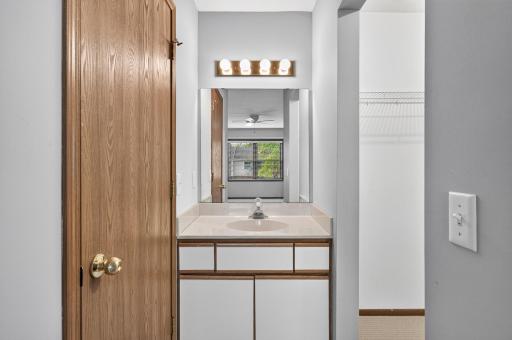 Additional vanity area with sink and mirror within primary bedroom.