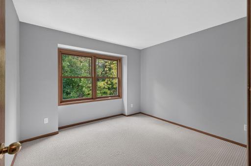 Upper-level secondary bedroom with a quiet view of the backyard.