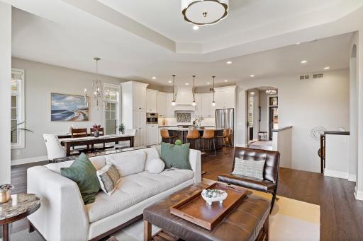 The sun-drenched main level features soaring ceilings, expansive windows, and an open-concept layout.