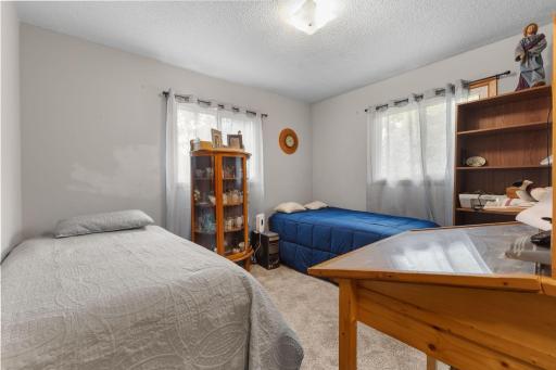 This upper-level bedroom offers multiple windows, carpeting, and neutral tones.