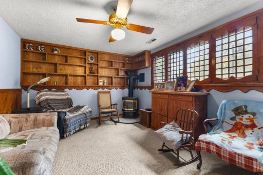 The lower-level family room is filled with character, featuring built-in shelving and a wood-burning stove.