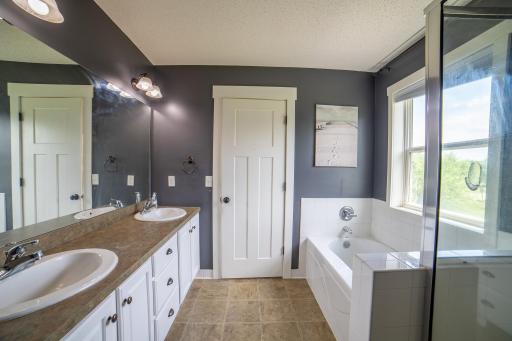 Primary ensuite bath with double vanity and separate tub and shower