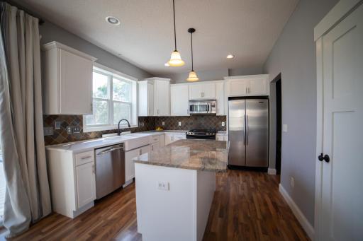 Kitchen with stainless appliances, quartz and granite counters